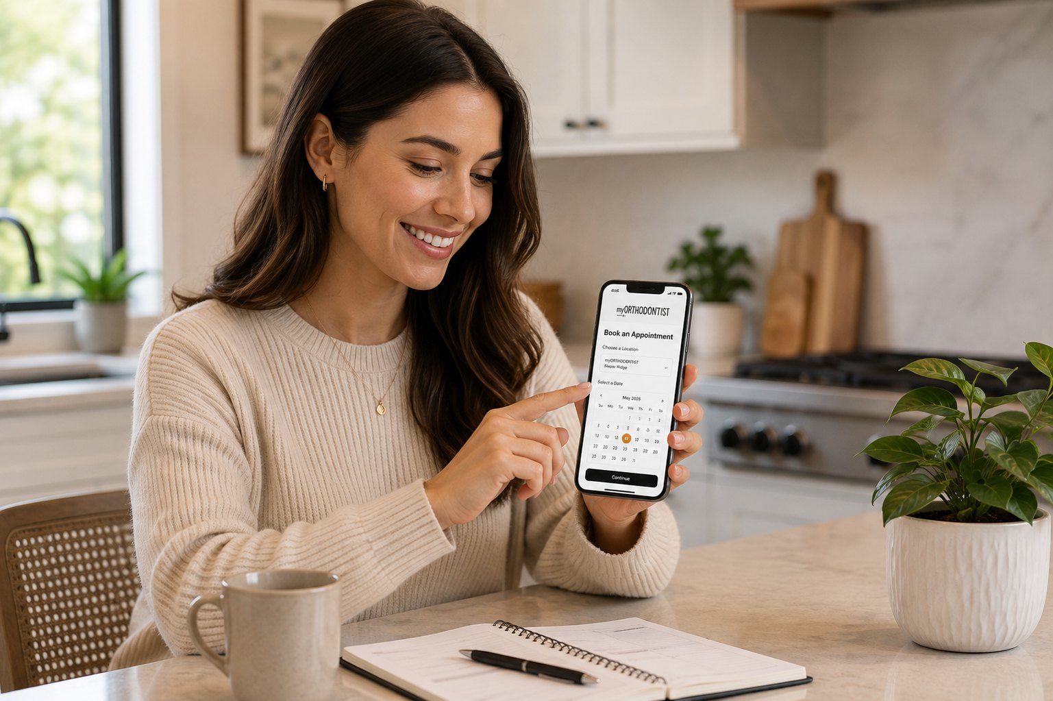 A woman booking an appointment on her phone at a kitchen counter